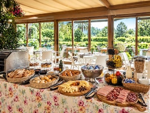 An outdoor buffet with various food items and a scenic view of greenery.