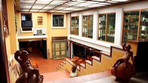 Un hall de hotel con una escalera, un televisor y una exhibición de objetos en la pared.