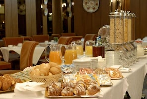 A breakfast buffet with pastries, juices, and cereal bars. - Hotel Delta Florence (Calenzano)