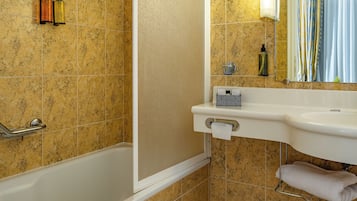 Un bagno con una vasca, un lavandino, uno specchio e una tenda da doccia.