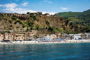 Un pueblo costero con playa, edificios y una colina.
