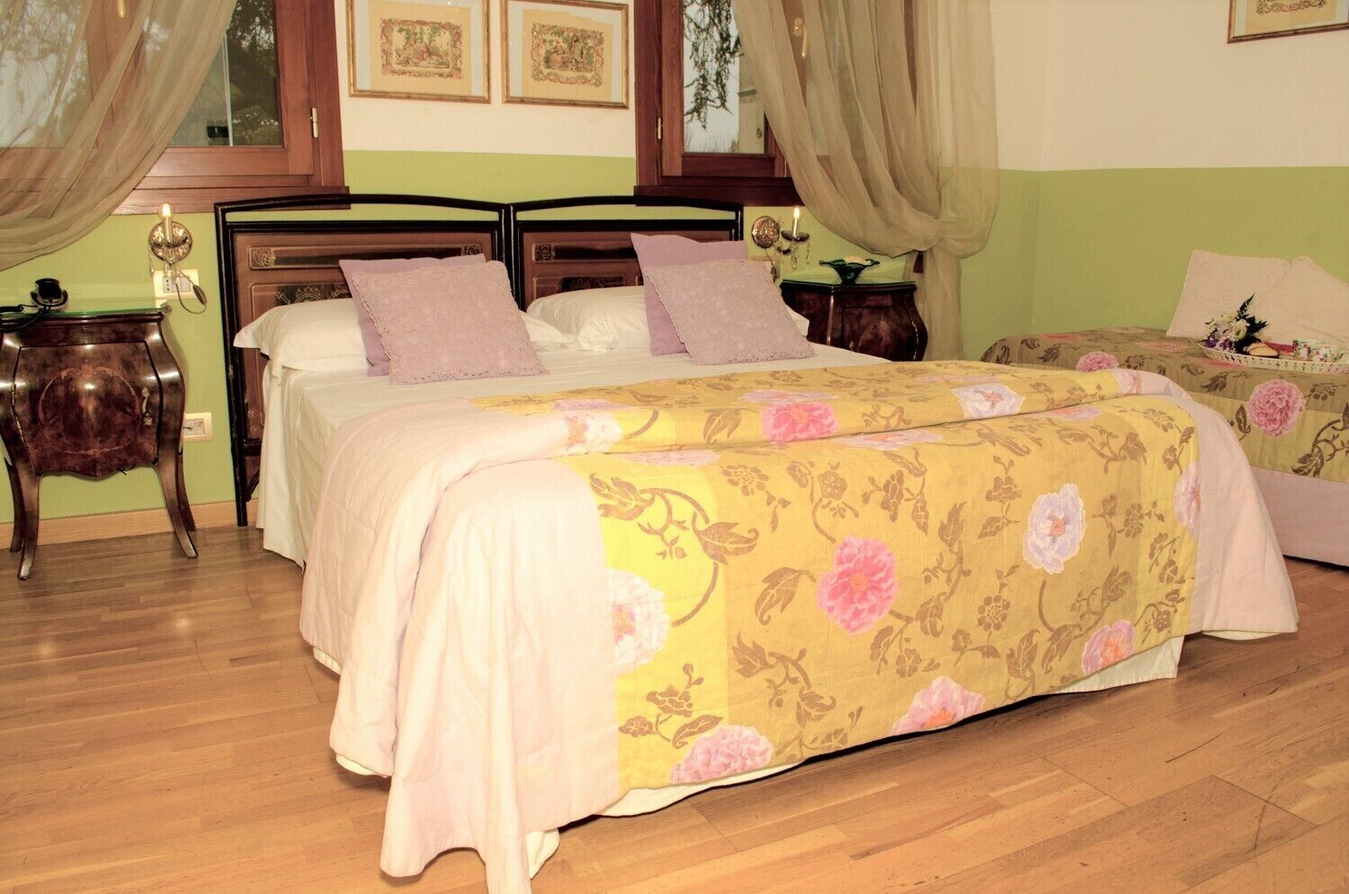 A bedroom with two beds, a nightstand, a dresser, and a window with curtains.