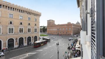 A street view with a historic building, a bus, and pedestrians.