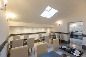 A modern dining area with a skylight, white walls, and contemporary furniture.