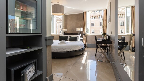 A hotel room with a bed, desk, and large windows. - Hotel Castellino Roma (Rome)