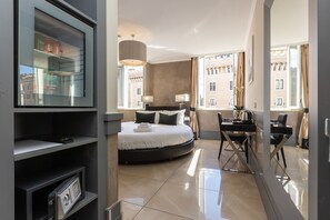 Une chambre d’hôtel avec un lit, un bureau et de grandes fenêtres.
