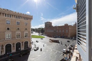 Una piazza cittadina con edifici storici, un tram e cielo sereno.