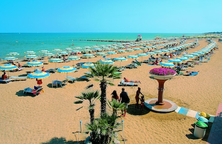 Sulla spiaggia, sabbia bianca, lettini da mare, ombrelloni. Hotel Meridianus