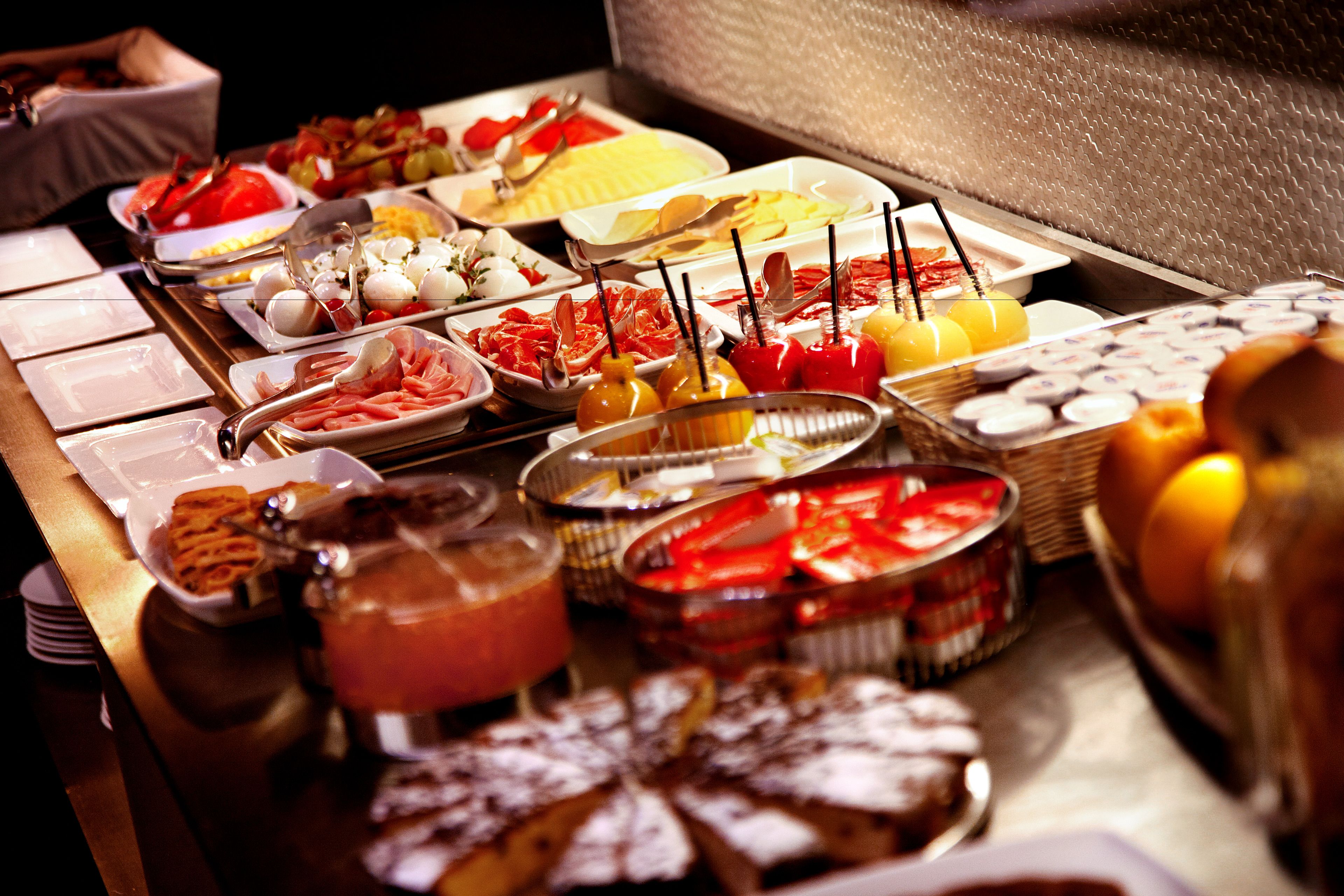 A buffet with various food items including fruits, cheeses, and pastries.