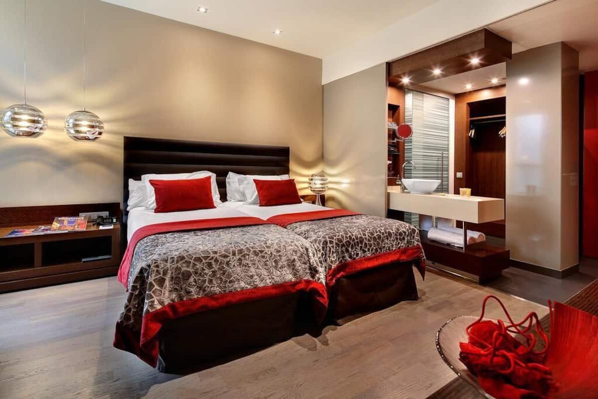 A modern bedroom with a large bed, a bedside table, and a built-in wardrobe.