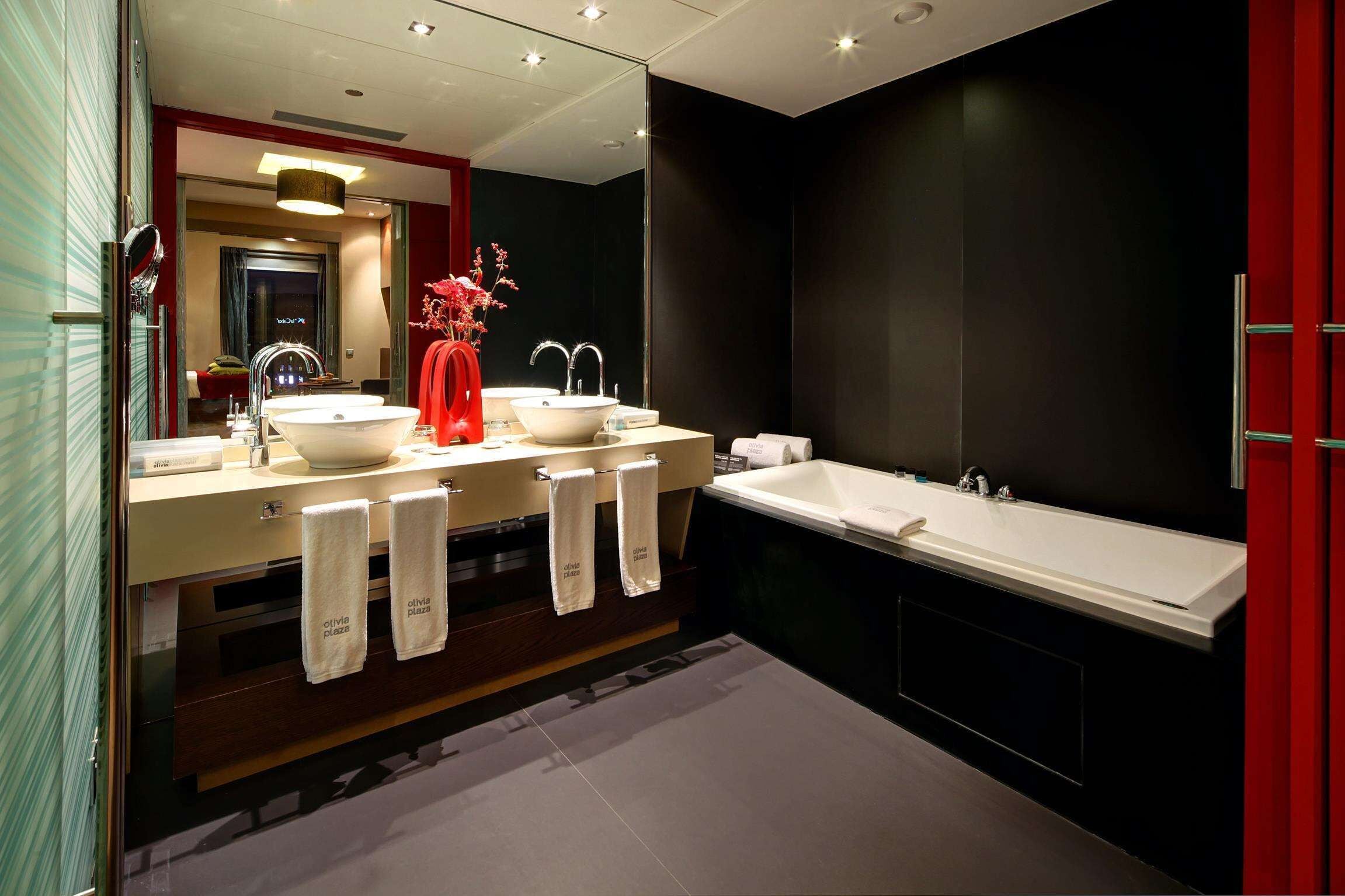 Une salle de bain moderne avec deux lavabos, une grande baignoire et un miroir.