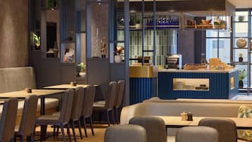 A modern restaurant with a bar area, seating arrangements, and decorative elements.
