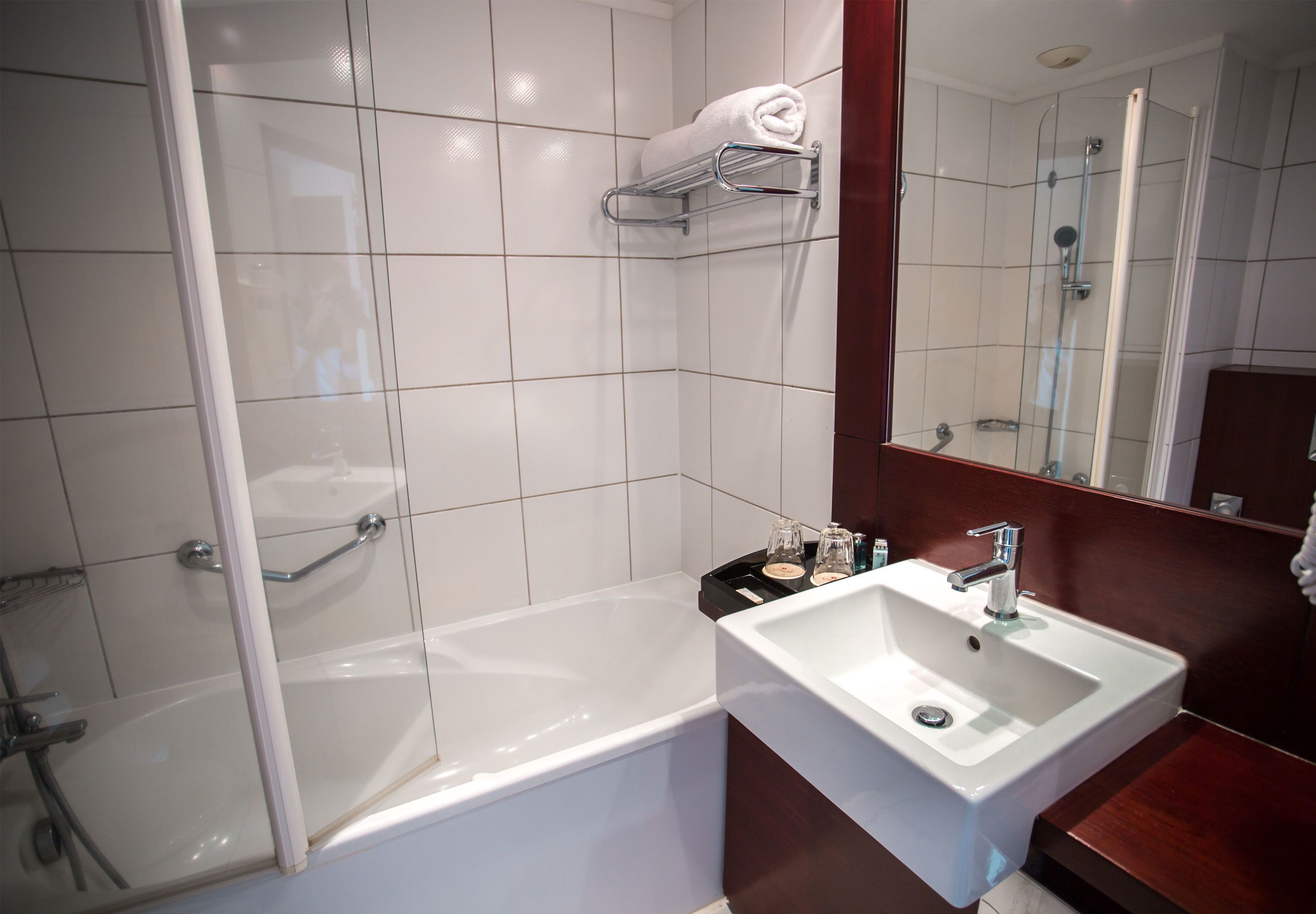 Une salle de bain moderne avec une baignoire, un lavabo et une douche à l’italienne.