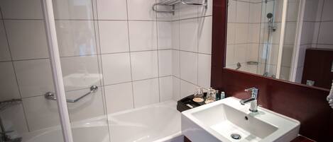 Une salle de bain moderne avec une baignoire, un lavabo et une douche à l’italienne.