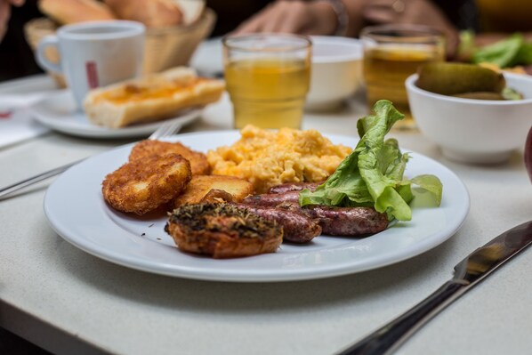 A breakfast plate with eggs, sausages, and toast. - Ramada Hotel & Suites Noumea (Nouméa)