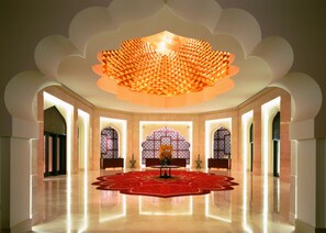 Experience the grandeur of this luxurious space with a high ceiling, polished floor, and intricate patterns.