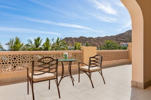 Enjoy breathtaking views of the surrounding mountains and palm trees from this balcony.
