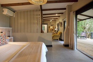 Habitación de hotel con una cama, un escritorio, una silla y vistas al exterior.