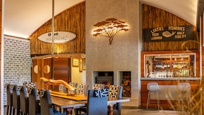 Un restaurante con pared de ladrillo, paneles de madera, chimenea y zona de bar.