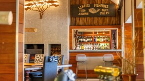 Zona de bar con un cartel que dice "Lerties Fisheries Fresh J.Bowman Daily Stall No3".