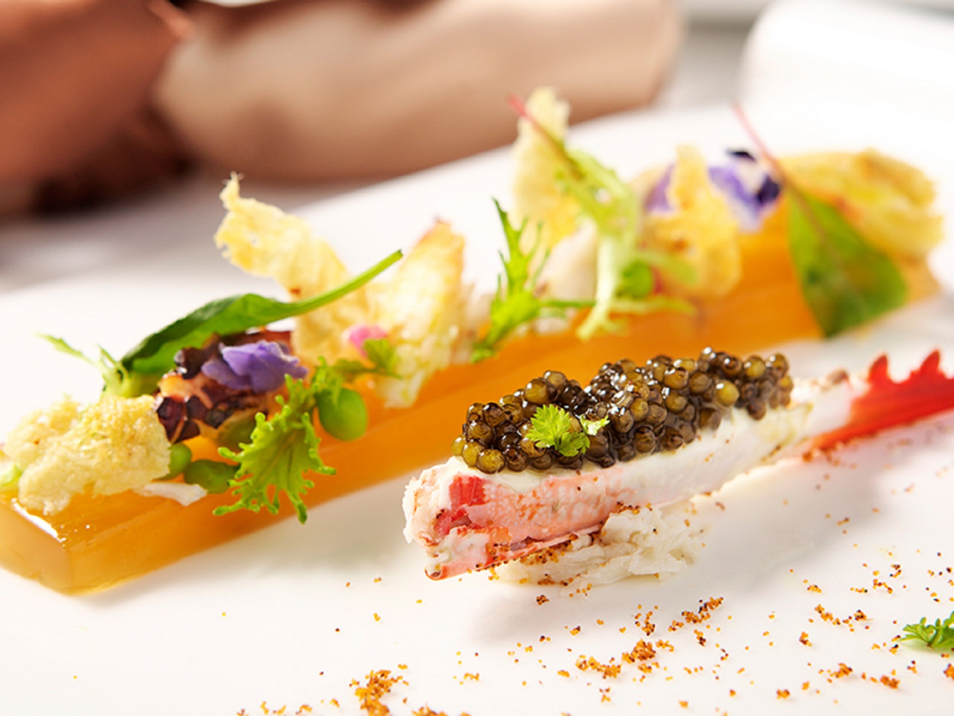 A seafood dish with caviar, garnishes, and a white plate.