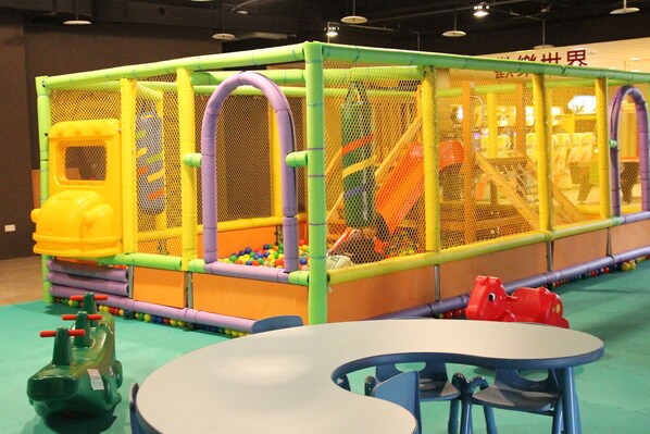 An indoor play area with a playpen, ball pit, and play structures. - Kentington Resort (Manzhou)