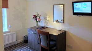 A small office with a desk, chair, and a computer monitor displaying an online shopping site. There is a mirror above the desk and a radiator below it. - Ely House Hotel (Wolverhampton)