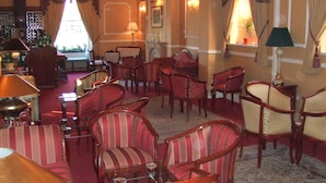 A hotel lobby with multiple seating areas, a bar, and a fireplace. - Ely House Hotel (Wolverhampton)