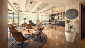A modern bar area with a circular sign reading "vero bar" and a potted plant. - Valamar Tirena Hotel (Dubrovnik)
