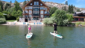 A house with a large balcony overlooking a lake, surrounded by greenery and hills. - Summerland Waterfront Resort & Spa (Summerland)