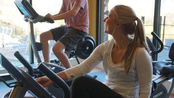 A gym with stationary bikes and a treadmill.