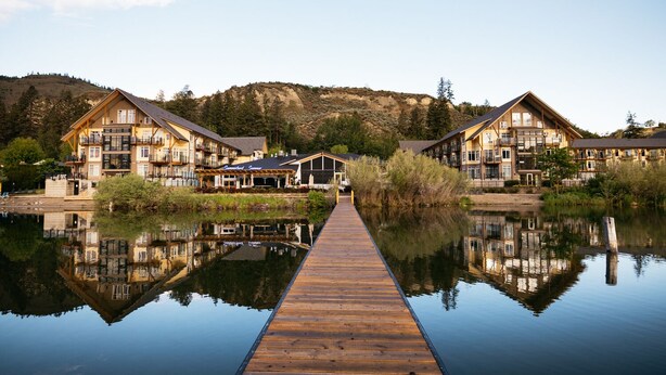 A lakeside hotel with a wooden dock leading to the water, surrounded by hills and trees. - Summerland Waterfront Resort & Spa (Summerland)