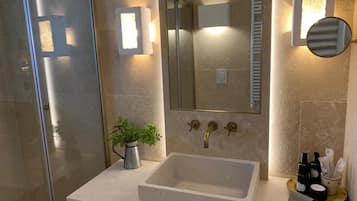 A bathroom with a large mirror, a sink, and a towel rack.