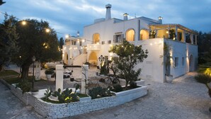 Un edificio blanco con ventanas de arco y un sendero de piedra que conduce a la entrada.