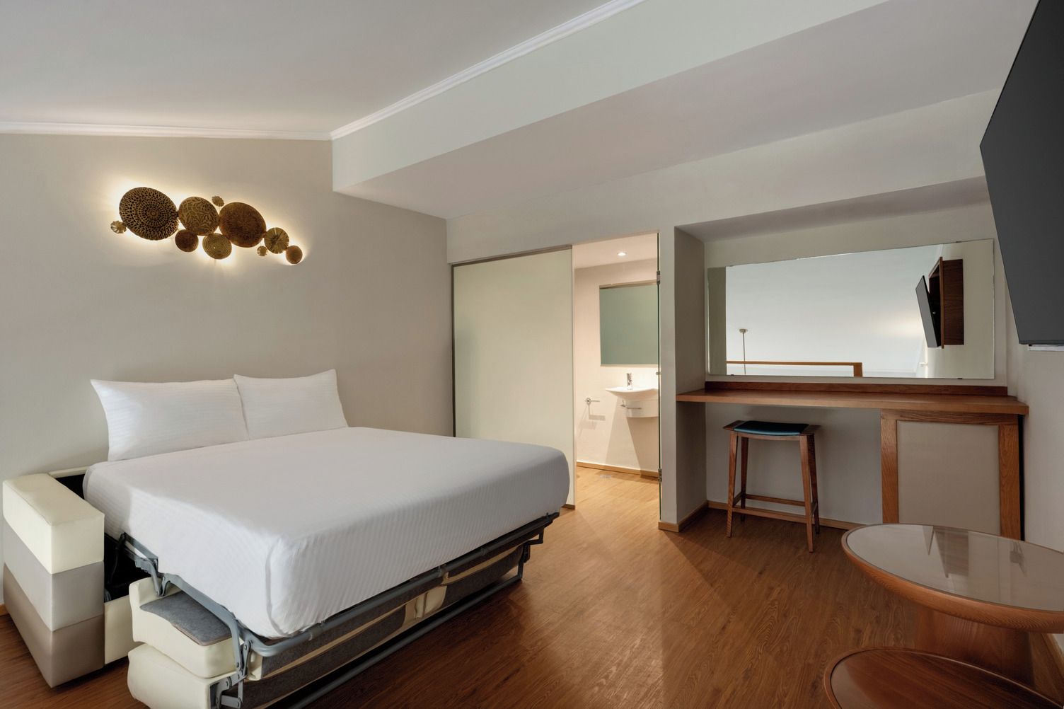 Une chambre d’hôtel moderne, équipée d’un lit, d’un bureau et d’une chaise.
