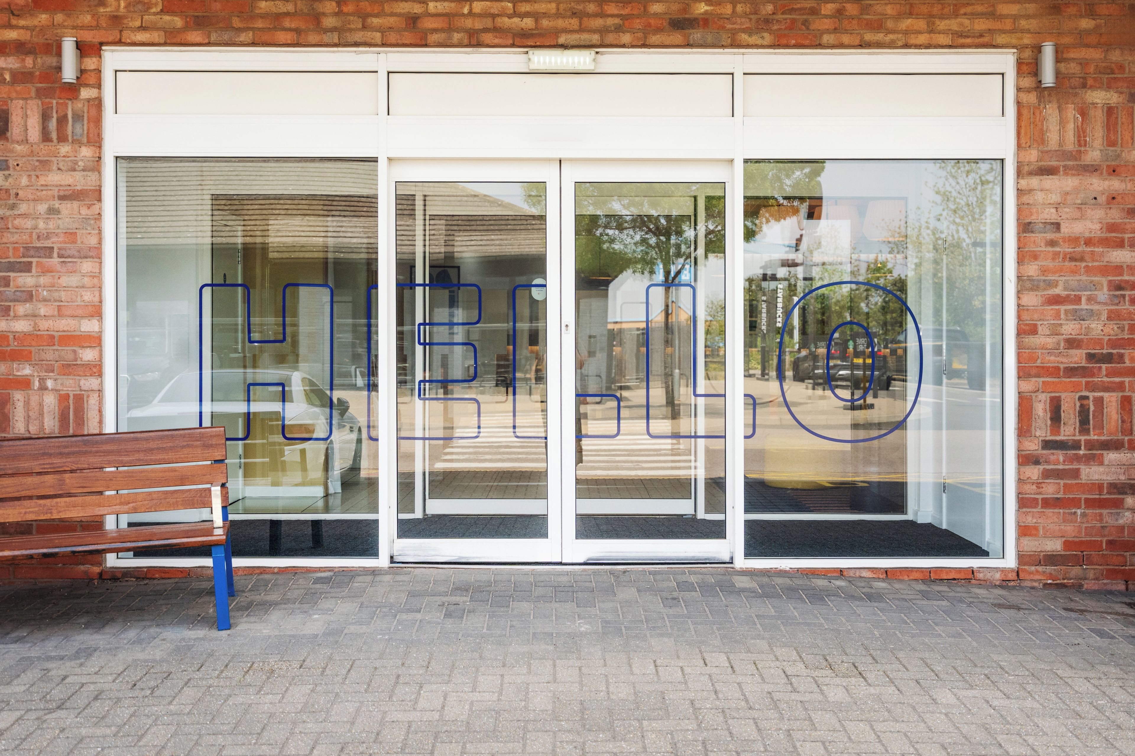 A building entrance with a bench outside.