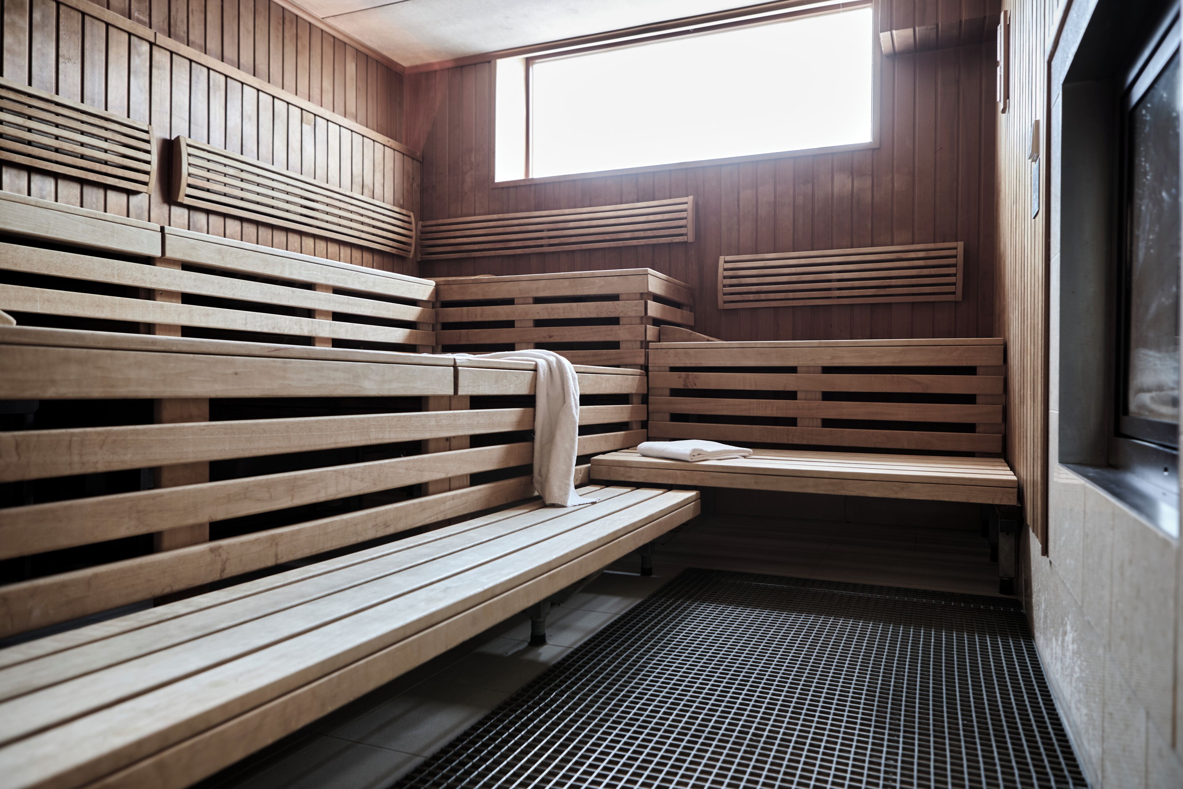 A sauna with wooden benches and a sloped ceiling.