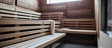 A sauna with wooden benches and a sloped ceiling.