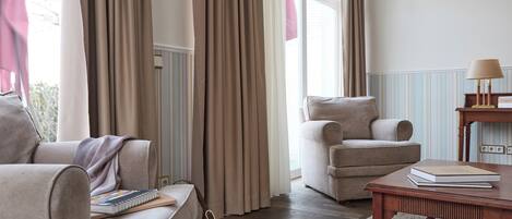 A living room with a sofa, armchair, and a table with a book.