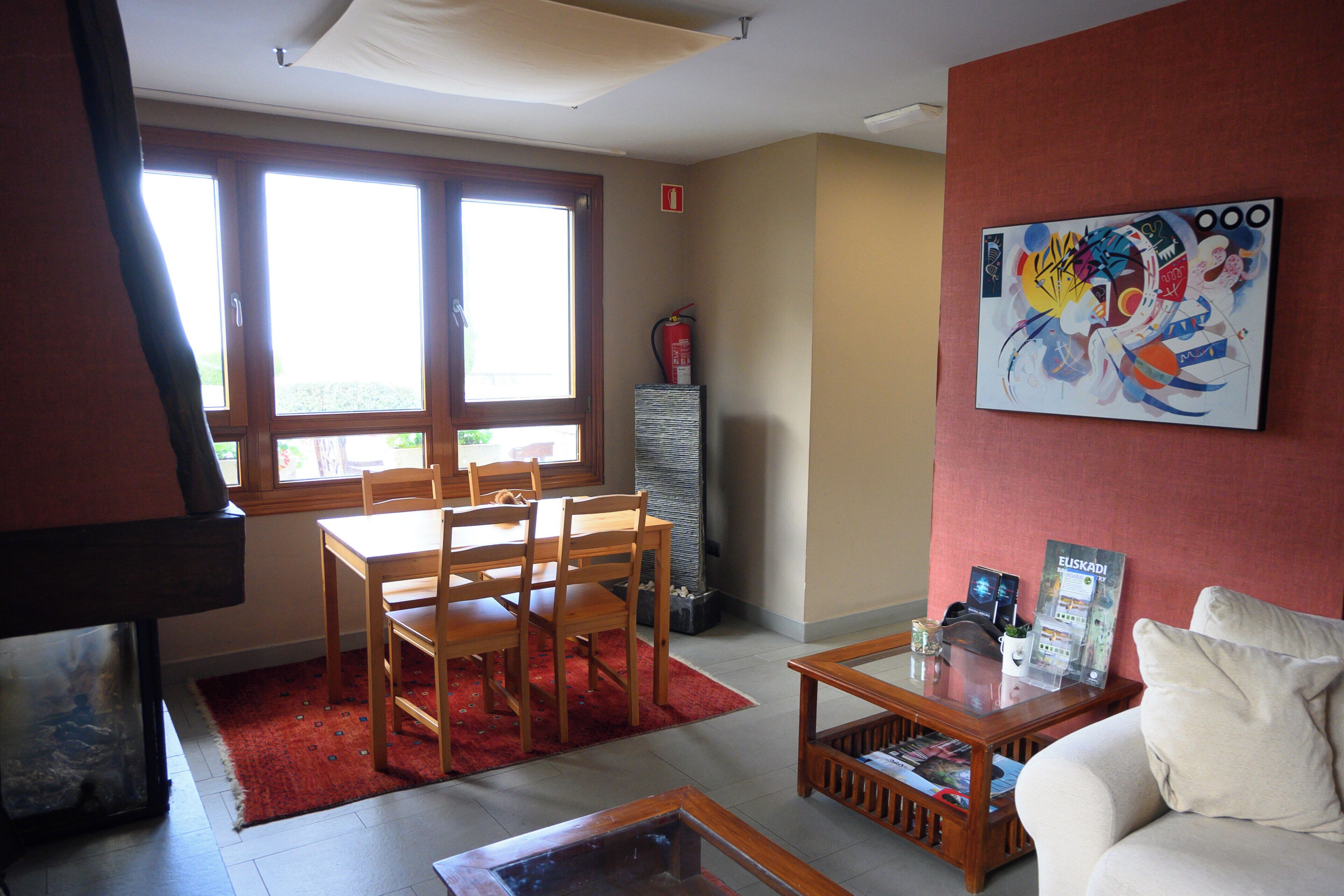 Una sala de estar con comedor, un sofá, una mesa de centro y un cuadro en la pared.