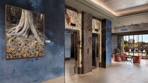 Eine moderne Lobby mit einem großen, abstrakten Gemälde, einer Rezeption und einer Sitzgelegenheit.