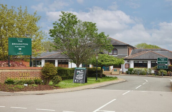 A hotel entrance with a sign welcoming visitors to The Broughton Pub & Hotel. - The Broughton Hotel By Greene King Inns (Milton Keynes)