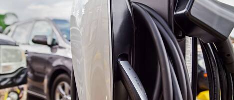 A car charging station with a charging cable connected to a vehicle.