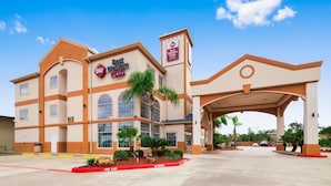 A Best Western Plus hotel with a large entrance, multiple windows, and a landscaped area with palm trees. - Best Western Plus Houston Atascocita Inn & Suites (Humble)