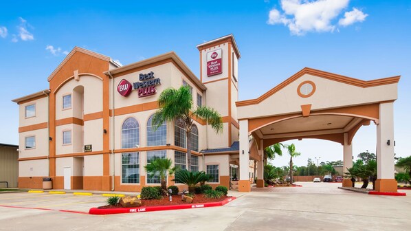 A Best Western Plus hotel with a large entrance, multiple windows, and a landscaped area with palm trees. - Best Western Plus Houston Atascocita Inn & Suites (Humble)
