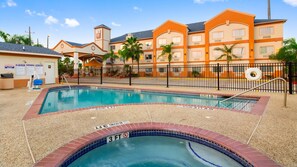 A hotel pool area with a clear pool edge, a lifeguard stand, and a sign indicating no diving. - Best Western Plus Houston Atascocita Inn & Suites (Humble)