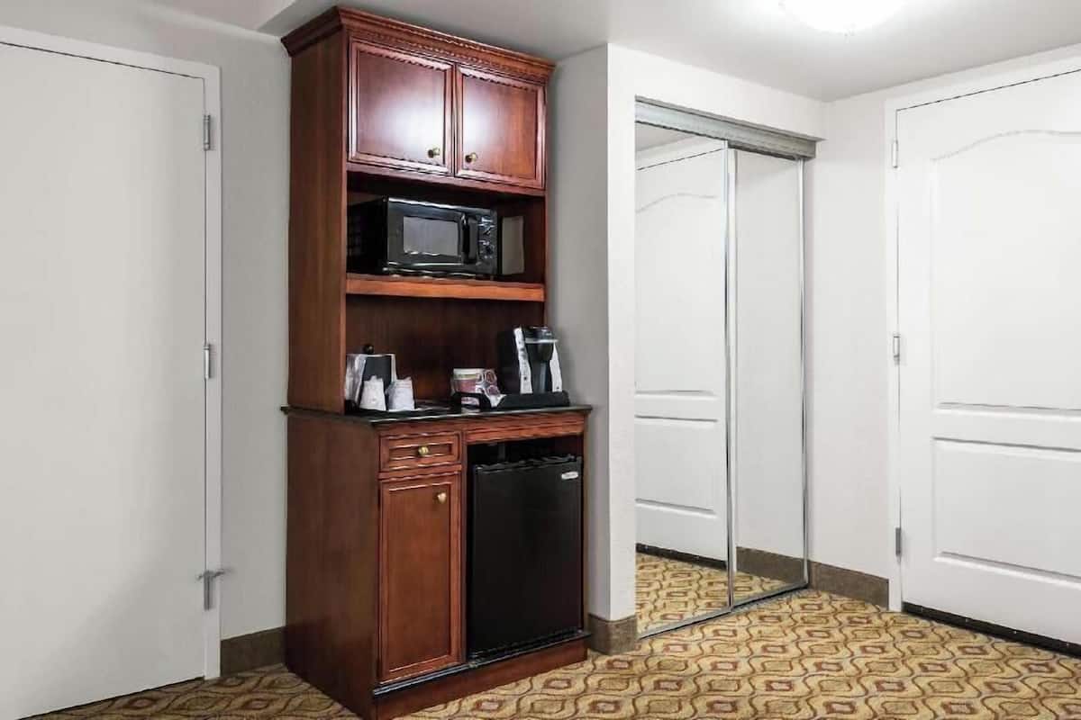 A compact kitchen with a microwave, coffee maker, and a small refrigerator.