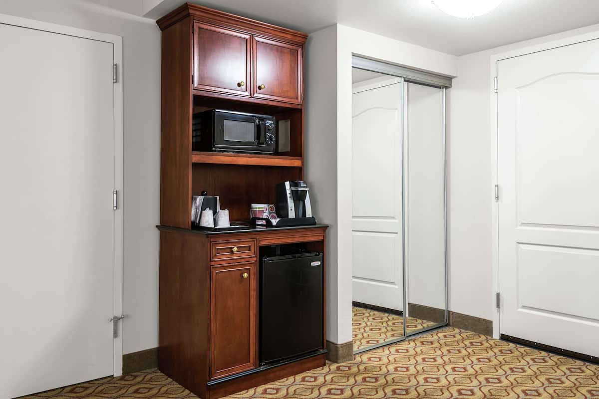 A compact kitchenette with a microwave, coffee maker, and refrigerator.