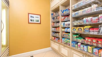 A pantry stocked with various food items and a framed picture on the wall.