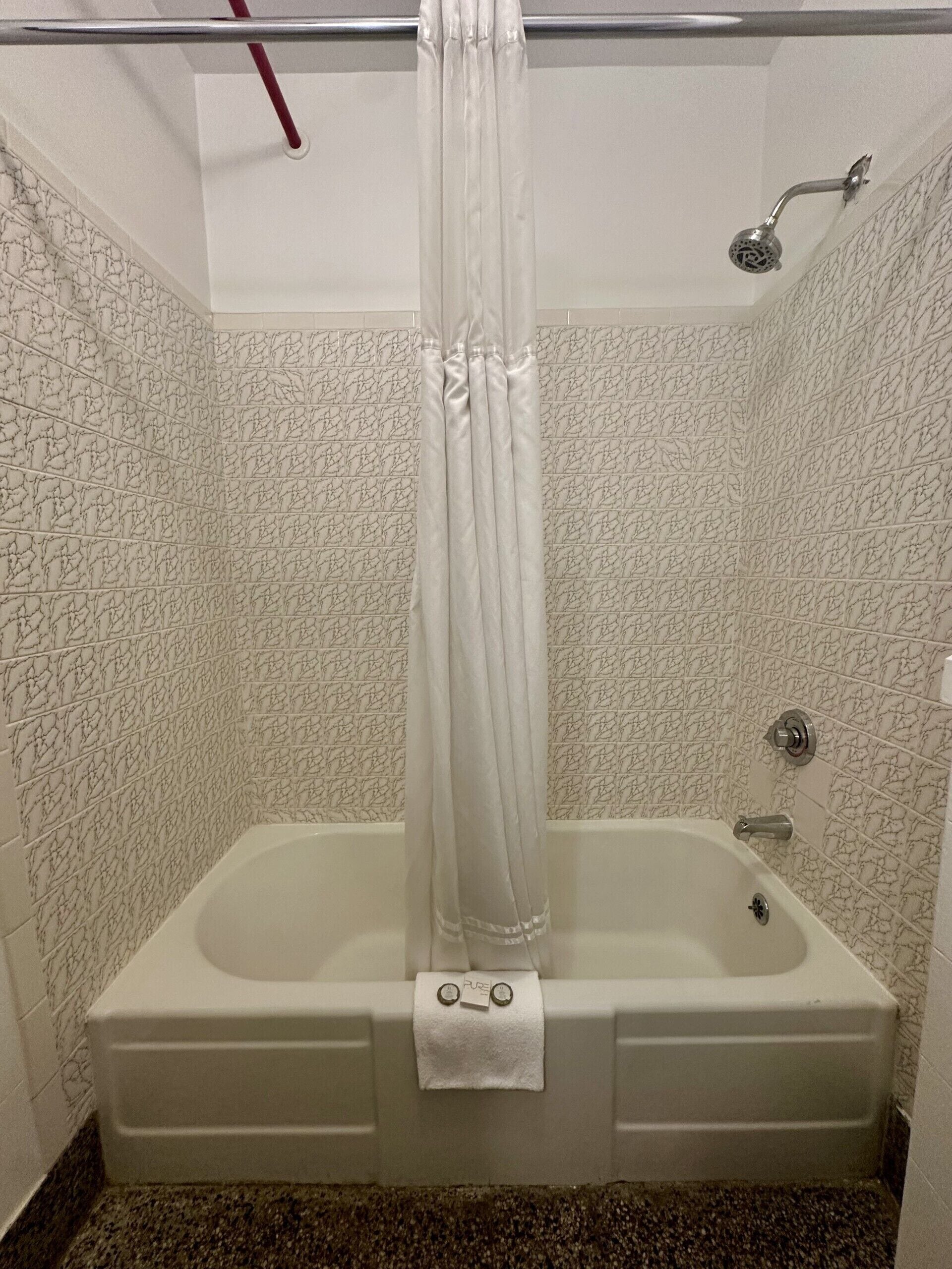 A bathroom with a bathtub, a shower, and a curtain.